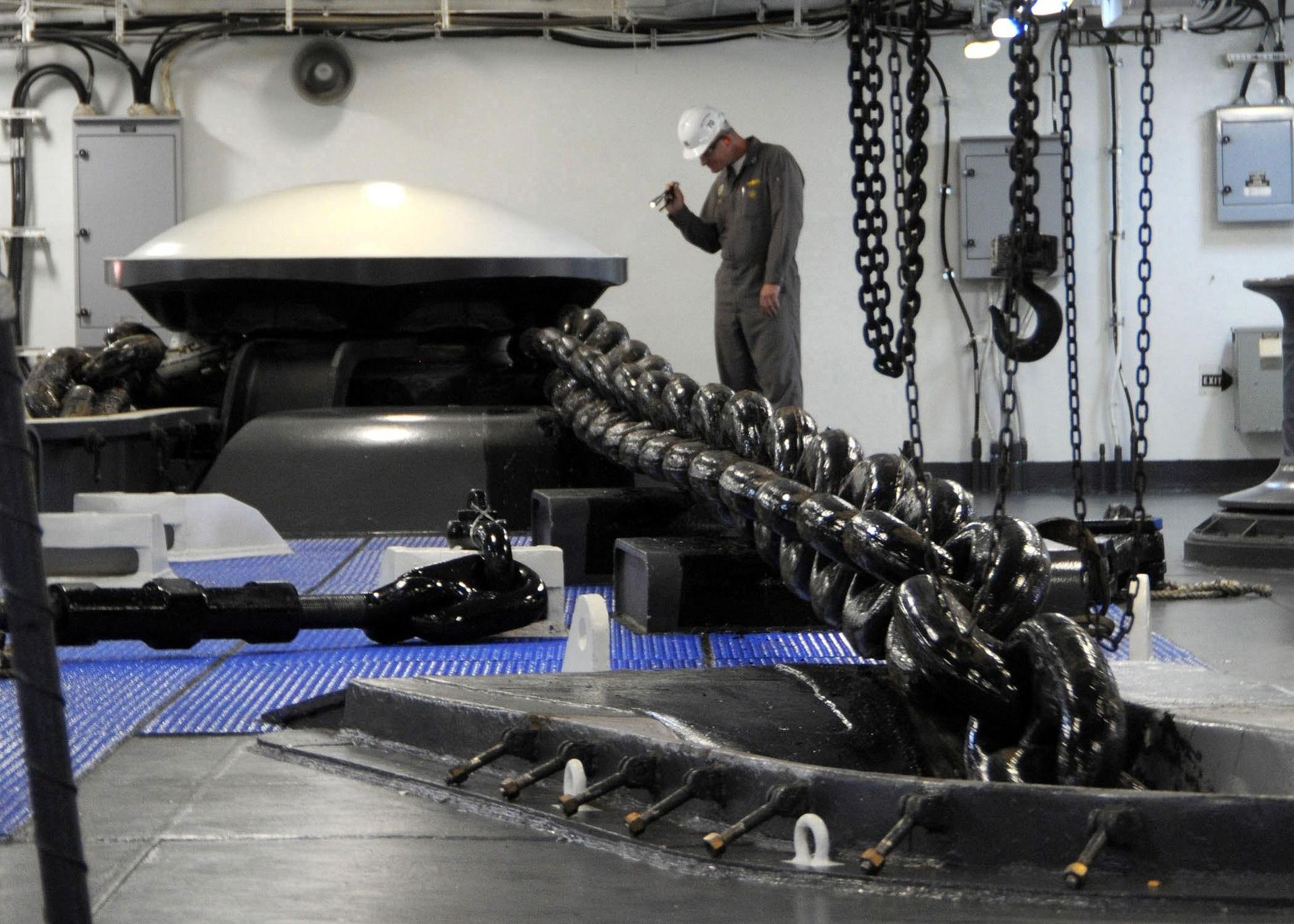 A ship's officer inspecting anchor chain on the forecastle