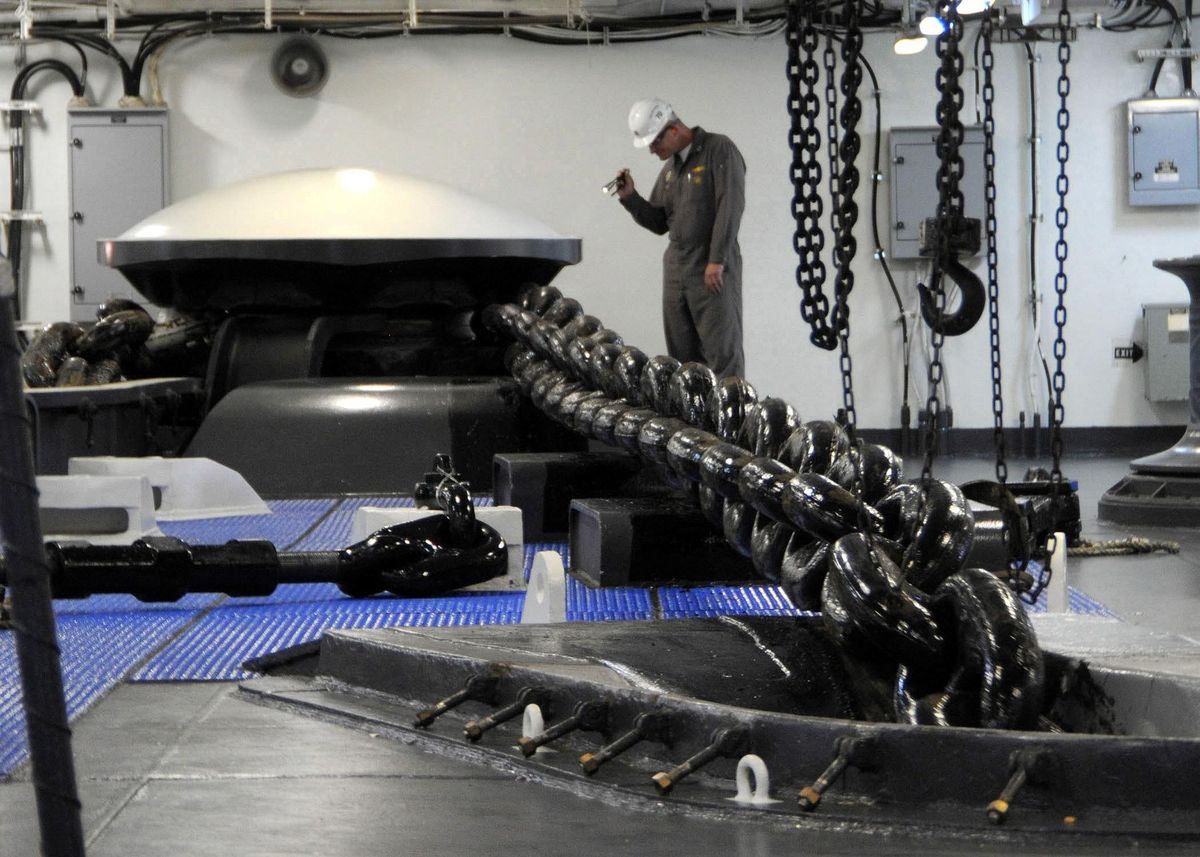 A ship's officer inspecting anchor chain on the forecastle